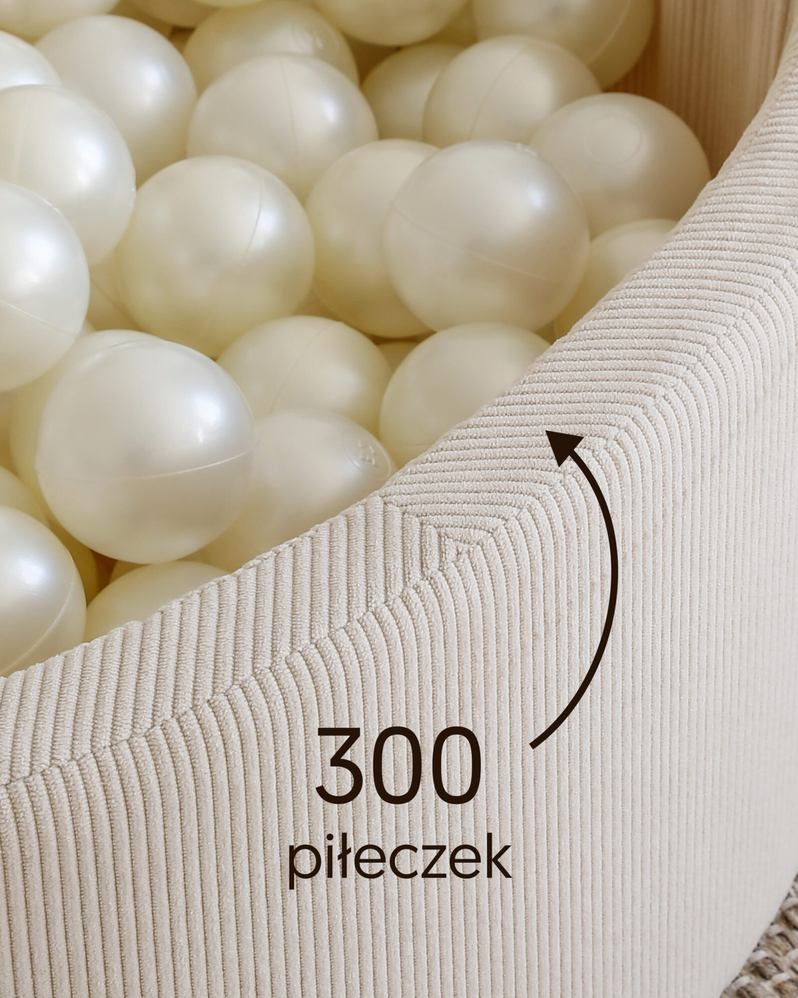Zbliżenie białych piłeczek w basenie cream z napisem „300 piłeczek”.