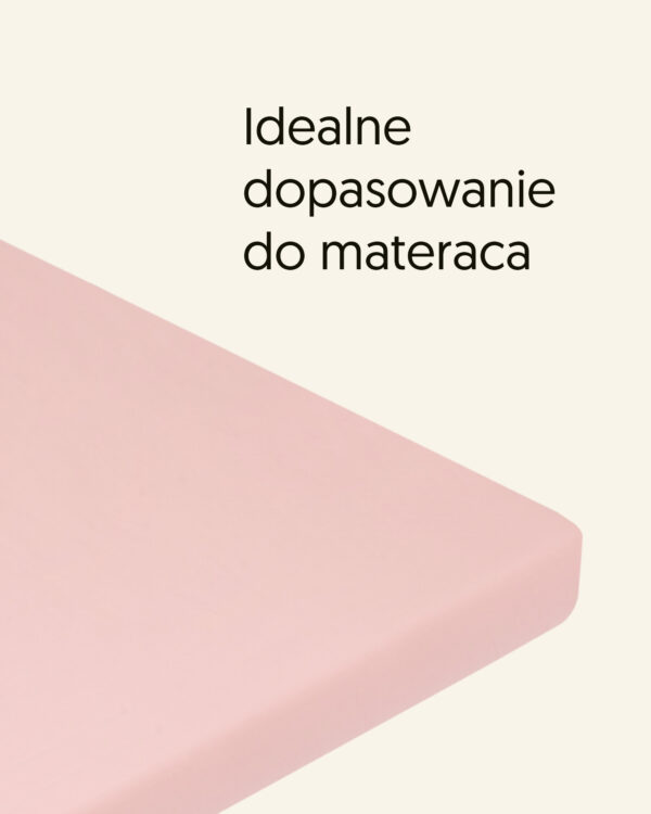 Prześcieradło w kolorze różowym na rogu materaca, z napisem „Idealne dopasowanie do materaca”.