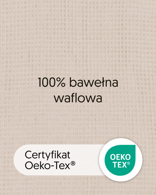 Zbliżenie bawełny waflowej w kolorze beżowym z tekstem „100% bawełna waflowa” i oznaczeniem OEKO-TEX.